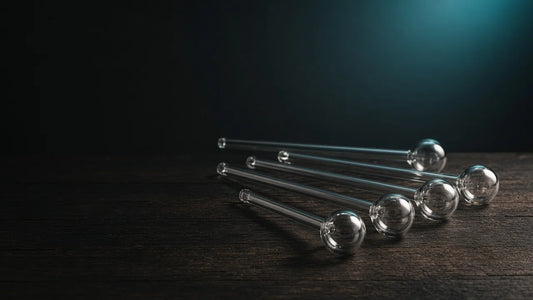 Clear glass oil burner pipes in different lengths fanned out on a wooden table